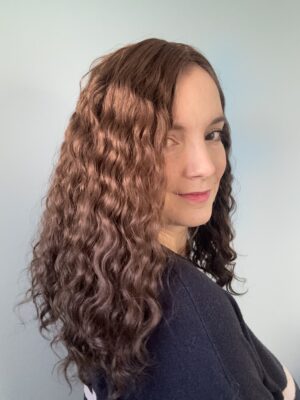 Volumateur capillaire chatain clair cendré bouclé en cheveux naturels. Pour alopécie androgénétique, cheveux fins ou clairsemés.