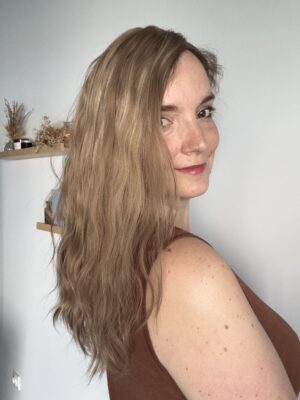 Le volumateur capillaire Anais est en cheveux naturels. C'est un blond doré illuminé de légères mèches blondes claires.